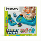 Discovery Kids Pottery Studio box, showing a child using the blue motorized wheel, clay, tools, and painted crafts.