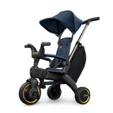 Doona Liki Trike S3 kids tricycle in navy blue with a canopy, black frame, and yellow accents.