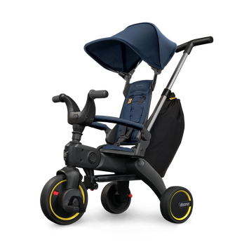 Doona Liki Trike S3 kids tricycle in navy blue with a canopy, black frame, and yellow accents.
