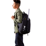 Man wearing a black Doona Liki Trike Travel Bag backpack with a trike handle extending from the top.