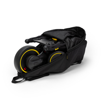 Black Doona Liki Trike Travel Bag, durable fabric, partially open with a folded Liki Trike inside.