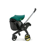 Black Doona Snap-on Storage bag attached to a black Doona stroller with a green canopy.