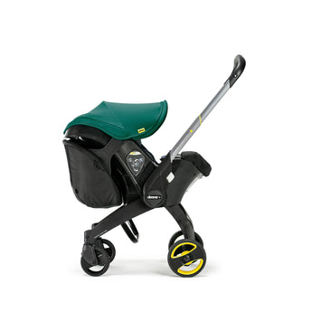 Black Doona Snap-on Storage bag attached to a black Doona stroller with a green canopy.