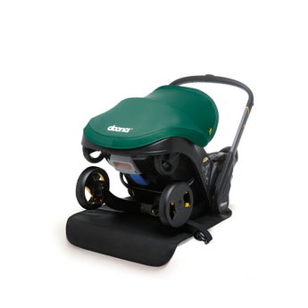 Doona Vehicle Seat Protector, a black mat under a green Doona infant car seat/stroller.