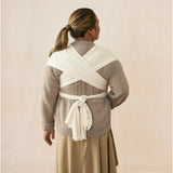 Woman from behind wearing an Ergobaby Aura sustainably sourced knit baby wrap in grey stripes.