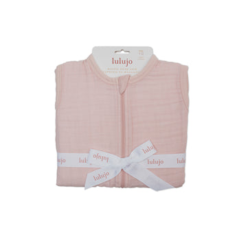 Lulujo 100% cotton muslin sleep sack in soft pink, folded and tied with a white logo ribbon.