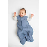 Happy baby in a blue Lulujo 100% cotton muslin sleep sack with a front zipper.