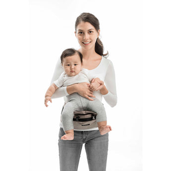 Smiling woman holding baby in a gray MiaMily Hipster ergonomic baby carrier with hip seat.