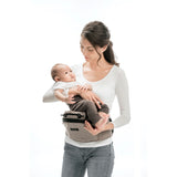 Woman holding baby with a beige MiaMily Hipster ergonomic baby carrier hip seat.