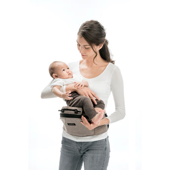 Woman holding baby with a beige MiaMily Hipster ergonomic baby carrier hip seat.