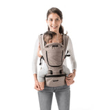 Smiling parent wearing a beige MiaMily Hipster ergonomic baby carrier with a baby facing forward.