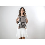 Woman in white dress carrying baby in a gray MiaMily Hipster ergonomic baby carrier with hip seat.