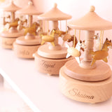 Personalized light wood music carousels with engraved names and spinning horses.