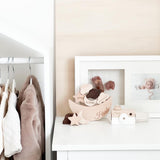 Personalized wooden camera toy with a white lens, next to a wooden moon sign with baby details.