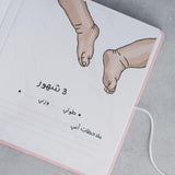 Open pink suede baby milestone album page with "3 شهور" (3 months), baby feet illustration, and dotted lines for details.