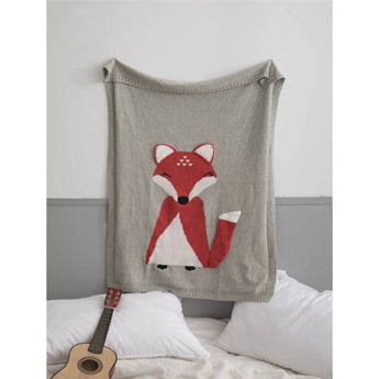 Cozy gray knit blanket with a charming red and white fox design, perfect for kids' rooms.
