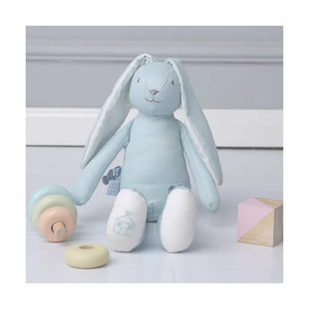 Soft blue personalized bunny plush toy with white feet, sitting next to a wooden stacking toy.