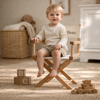 Blonde child in a personalized My Little Thieves French oak and white canvas director chair with "Beau" embroidered.