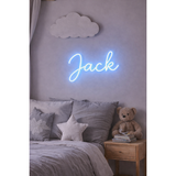 Blue LED neon sign "Jack" in script font, on a gray wall above a bed with gray linens.