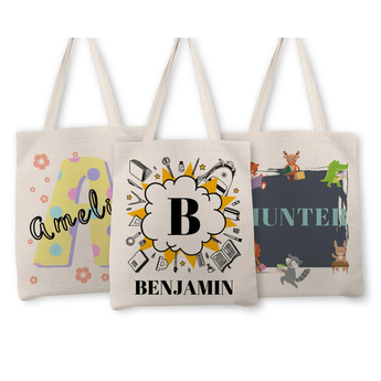 Three personalized natural cotton tote bags: one with a yellow polka-dot "A" and "Amelia," one with a "B" surrounded by school supplies and "Benjamin," and one with "Hunter" and woodland animals.