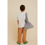 Boy from behind wearing a beige organic cotton Potato Face Kid's T-shirt and brown pants.
