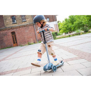 Young child in helmet riding a blue Scoot & Ride Highwaykick 3S LED 3-wheel light-up scooter.