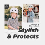 Two young girls wearing light grey Scoot & Ride eco-friendly kids helmets, one smiling at the camera.