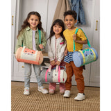 Three smiling kids hold Skip Hop Duffimals duffle bags: a pink cat, a gray panda, and a blue dinosaur.