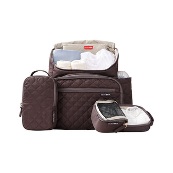 Brown quilted Skip Hop Forma nappy bag with open compartments, packing cubes, baby clothes, and bottle.