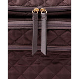 Close-up of a dark brown quilted Skip Hop Forma backpack with gold zippers and leather pulls.