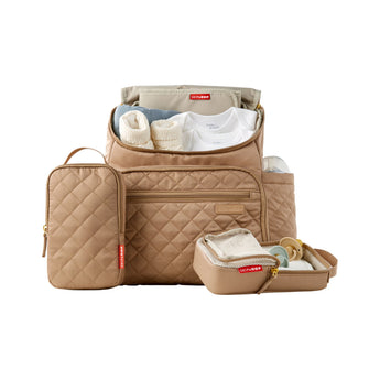 Tan quilted Skip Hop Forma backpack nappy bag, open with baby clothes, bottle, and two packing cubes.