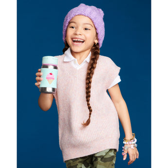 Smiling girl in a purple beanie holding a Skip Hop stainless steel straw bottle with an ice cream design.