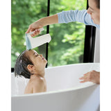 White and light blue Skip Hop Moby Waterfall Rinser used by an adult to rinse a child's hair in a white tub.