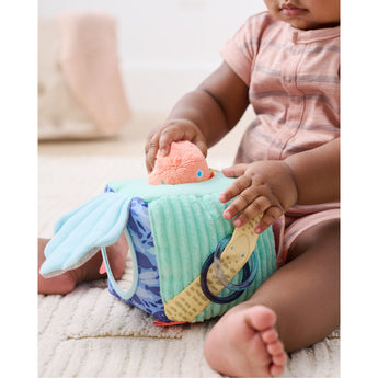 Baby playing with a soft, multi-textured Skip Hop Seascape Activity Cube featuring a puffer fish and teether.