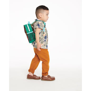 Toddler boy in a tropical shirt and orange pants, wearing a green Skip Hop Zoolet Bee Mini Backpack.
