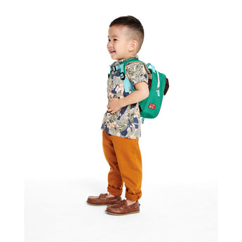 Toddler boy wearing a green Skip Hop Zoolet backpack with a bee design and detachable tether.