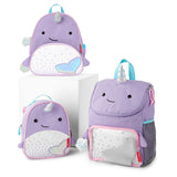 Three purple Skip Hop narwhal backpacks: a large backpack, a mini backpack, and a lunch bag, all with iridescent horns and tails.