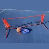 KickerBall Soccer Tennis game with orange net, blue carrying bag, orange and blue ball, and pump on a blue court.