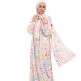 Woman wearing a colorful floral dress and headscarf on a white background
