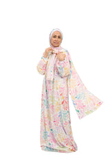 Woman wearing a colorful floral dress and headscarf on a white background