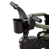 Black Doona Liki Cup Holder attached to a Liki Trike handlebar, holding a toddler's drink.
