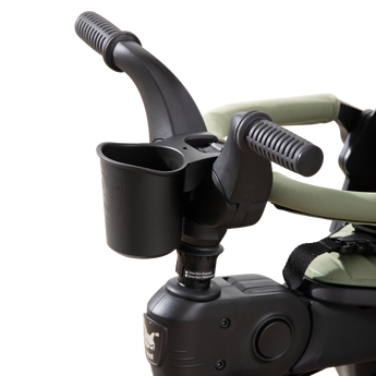 Black Doona Liki Cup Holder attached to a Liki Trike handlebar, holding a toddler's drink.