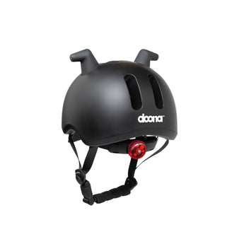 Doona Liki Helmet Black with unique silicon horns, vents, adjustable chin strap, and red rear light.