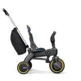 Doona Liki Trike S3 kids tricycle in black with yellow accents, a navy seat, and a rear storage bag.