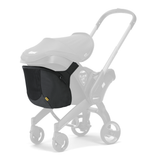 Black Doona Snap-on Storage bag attached to the back of a gray Doona stroller frame, featuring mesh sides and a yellow tag.