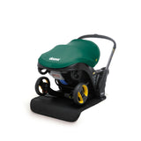 Doona Vehicle Seat Protector, a black mat, under a green Doona infant car seat/stroller.