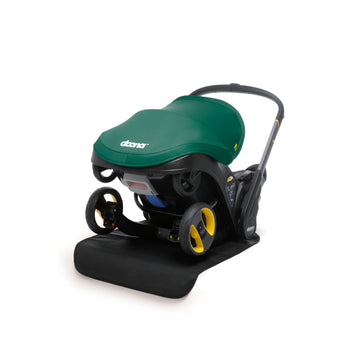 Doona Vehicle Seat Protector, a black mat, under a green Doona infant car seat/stroller.