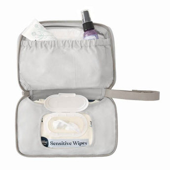Open gray Ergobaby portable changing pad with wipes, cream, and spray bottle inside.