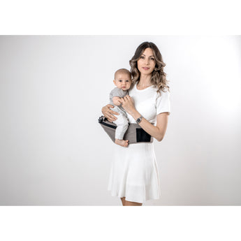 Woman in white dress holding baby in a gray MiaMily Hipster ergonomic baby carrier with hip seat.
