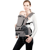 Woman wearing a gray MiaMily Hipster ergonomic baby carrier with a baby facing forward.